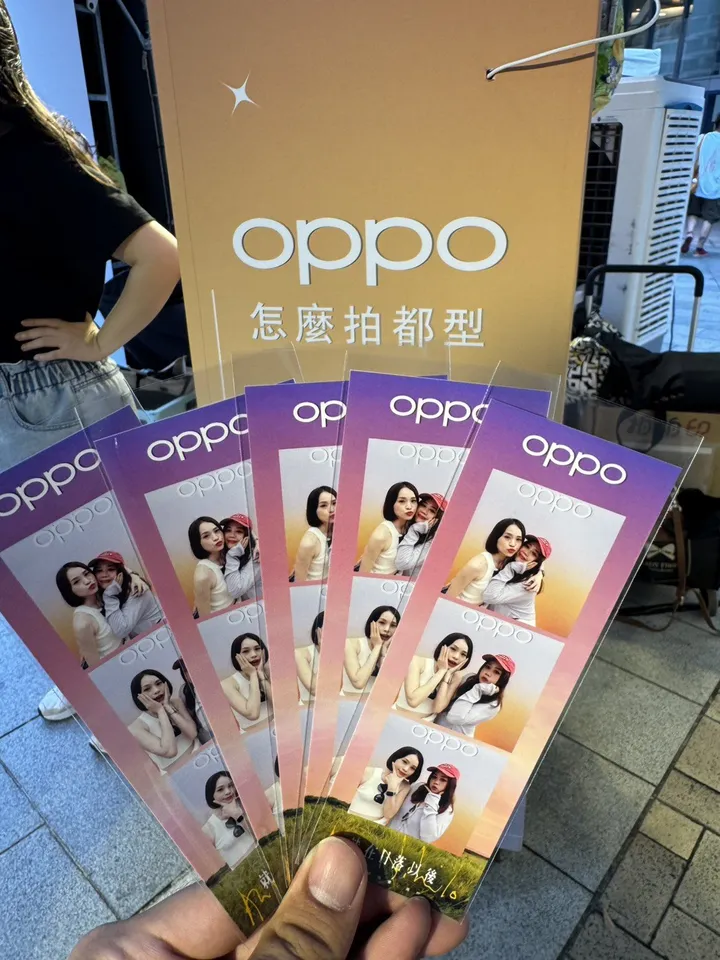 手持多條 OPPO 品牌邊框拍貼條,背景為 OPPO 主視覺立牌