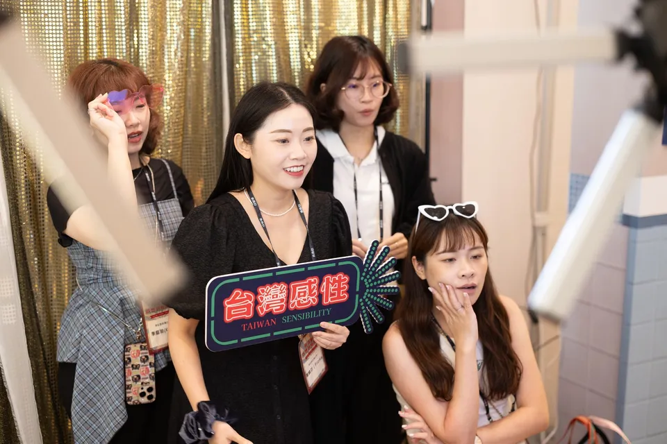 賓客手持霓虹手舉牌與眼鏡道具,在定點拍照亭前多人合照